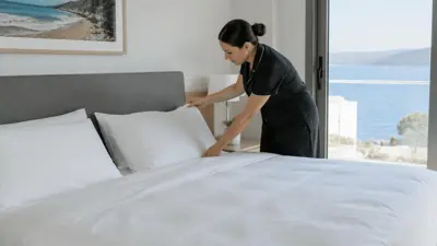 Cleaner arranging bedding in a holiday apartment