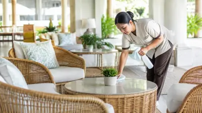 Cleaner wiping a table in a resort lounge