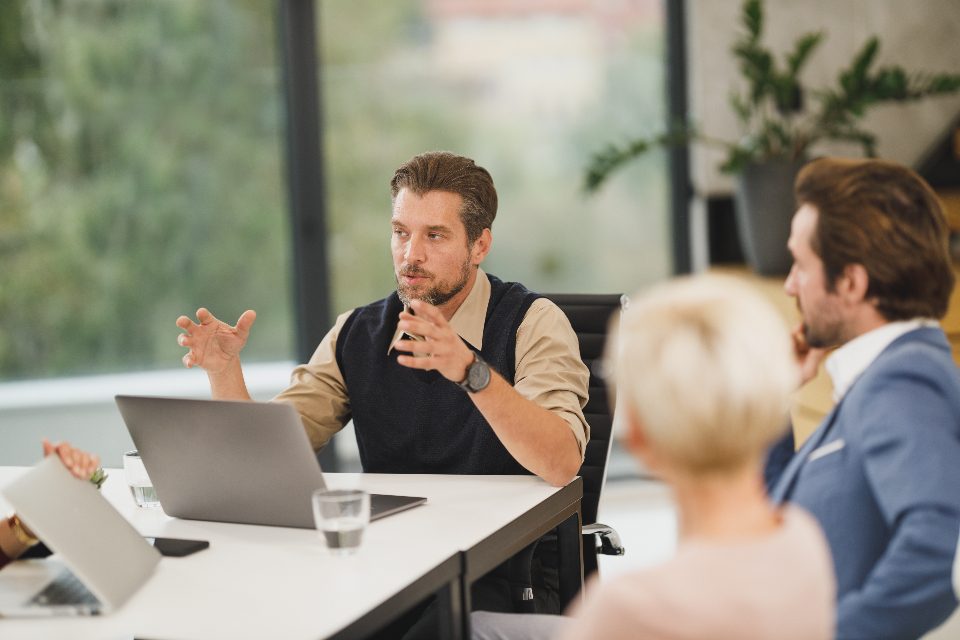 Colleagues meeting around a boardroom table in a clean office