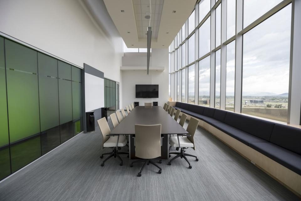 Empty office meeting room with clean floors, chairs and glass windows